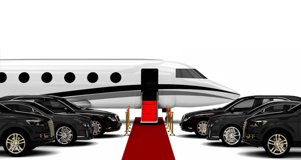 Private jet with luxury cars and a red carpet.