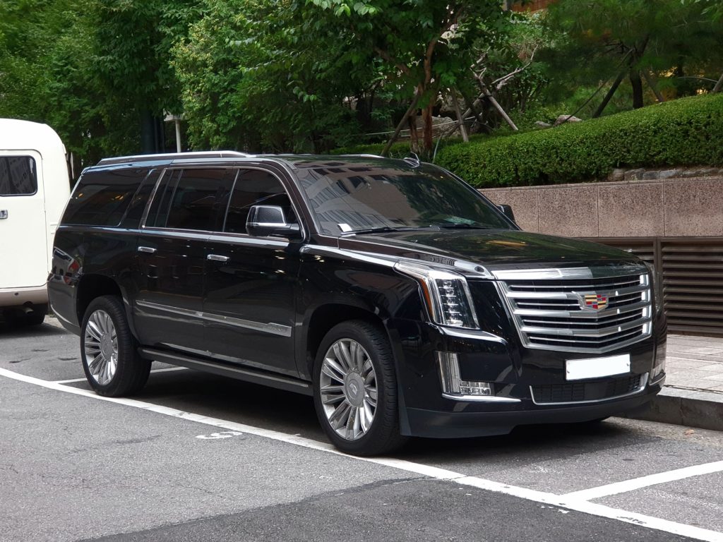 A sleek black Cadillac Escalade parked on a city street.